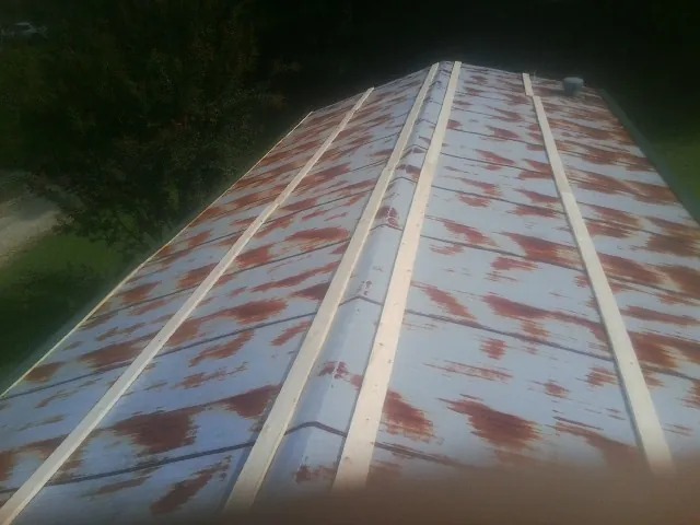Rusted metal roof panels with new wood purlins before replacement — Storm Damage Roof Repair in Rochert by Roofing Brothers