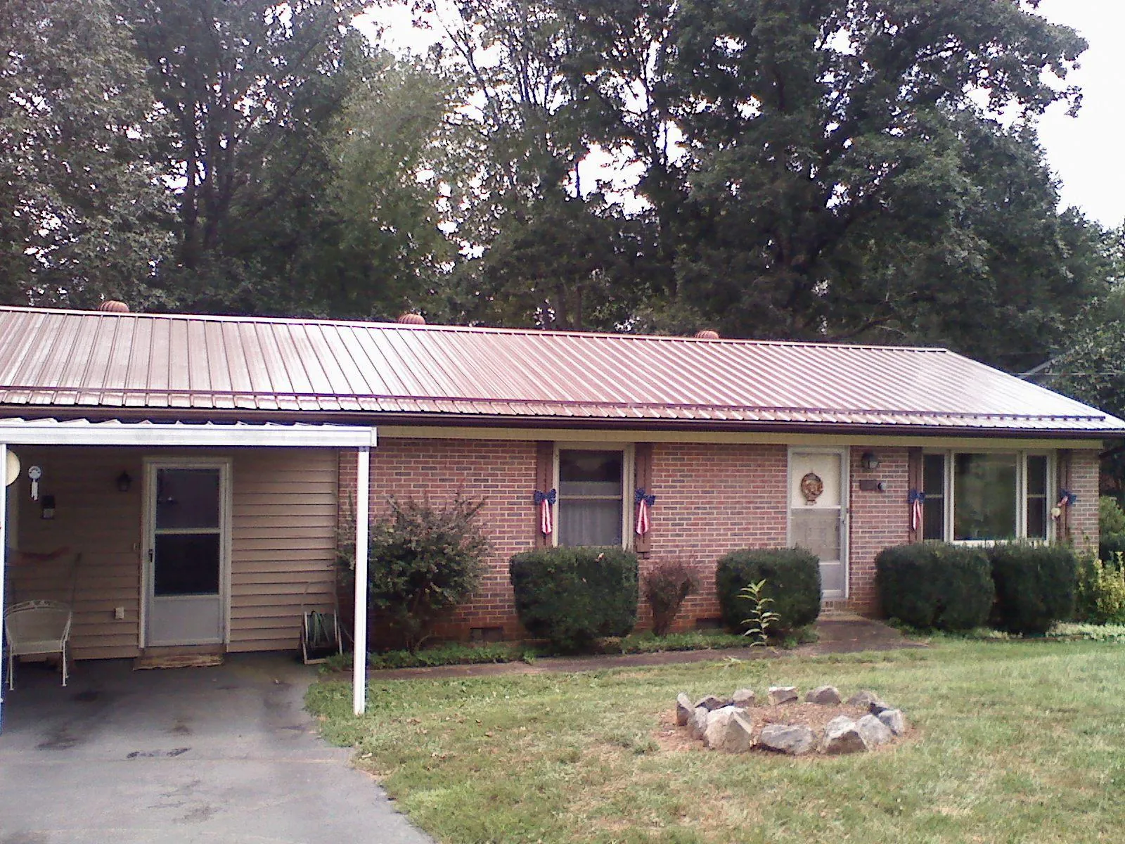 Bronze metal roof and carport on a brick ranch home — Roof Repair work by our crew in Rochert